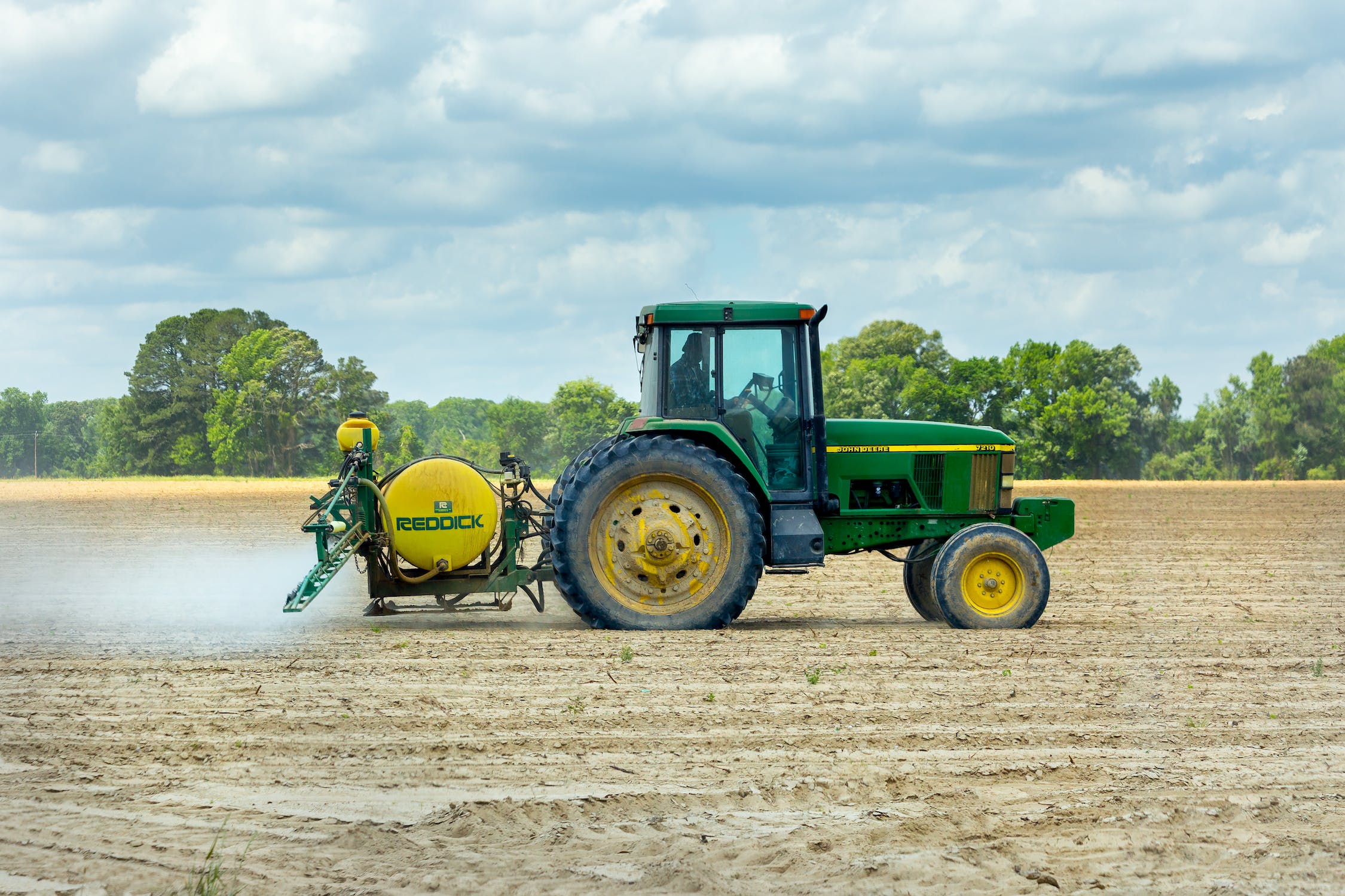 Farmer spraying crops with pesticide in a field